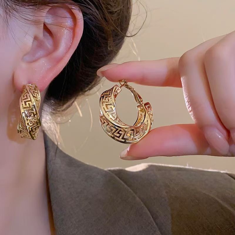 Boucle d'oreille dorée femme chic torsadée