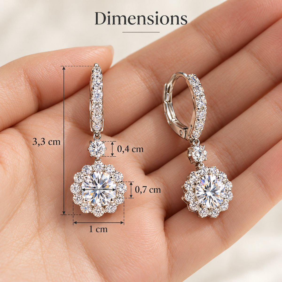 Boucles d’oreilles pendantes fleur en zircone, couleur or blanc, présentées sur un tissu anthracite. NaharaBijoux