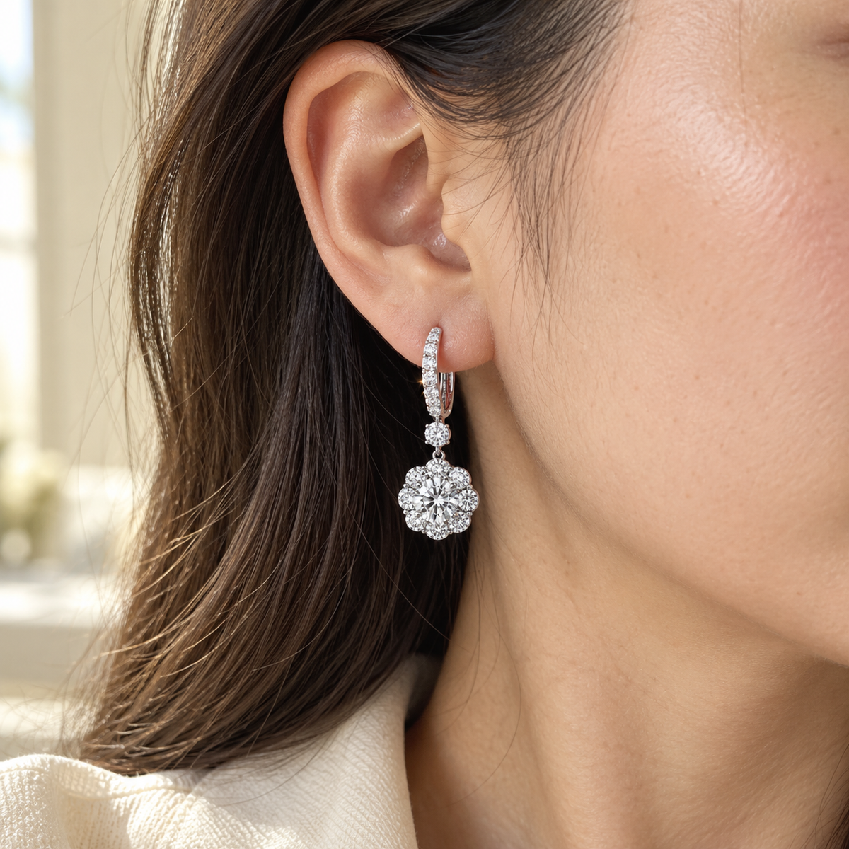 Boucles d’oreilles pendantes fleur en zircone, couleur or blanc, présentées sur un tissu anthracite. NaharaBijoux